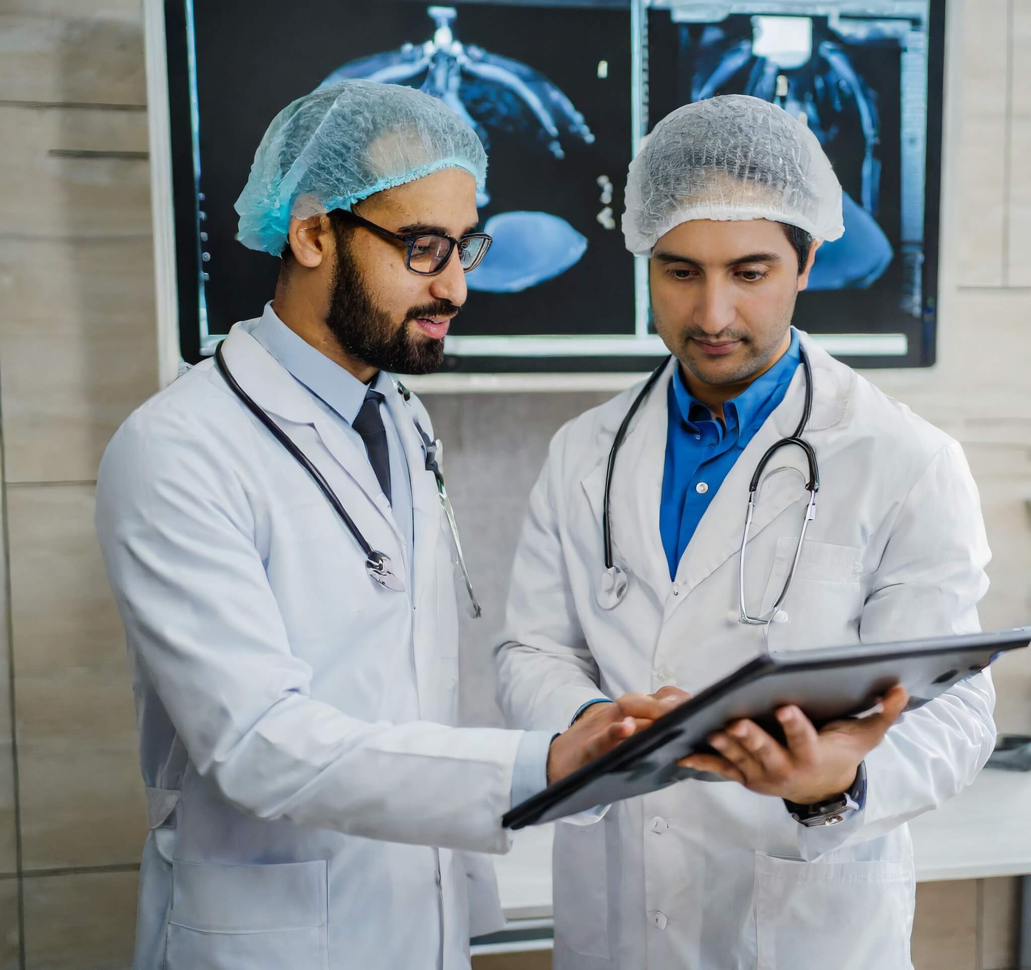 Two experienced gastroenterologists in white coats scrutinize the endoscopy results on a large medical monitor